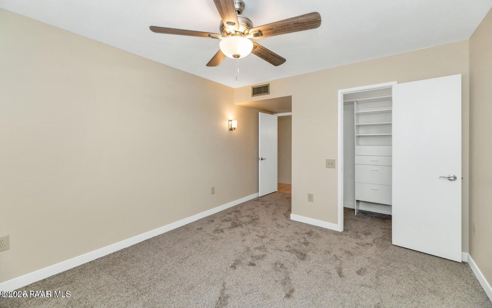 12602 West Rampart Drive Sun City, AZ 85375 - Photo 15 of 28 an empty room with closet and a ceiling fan