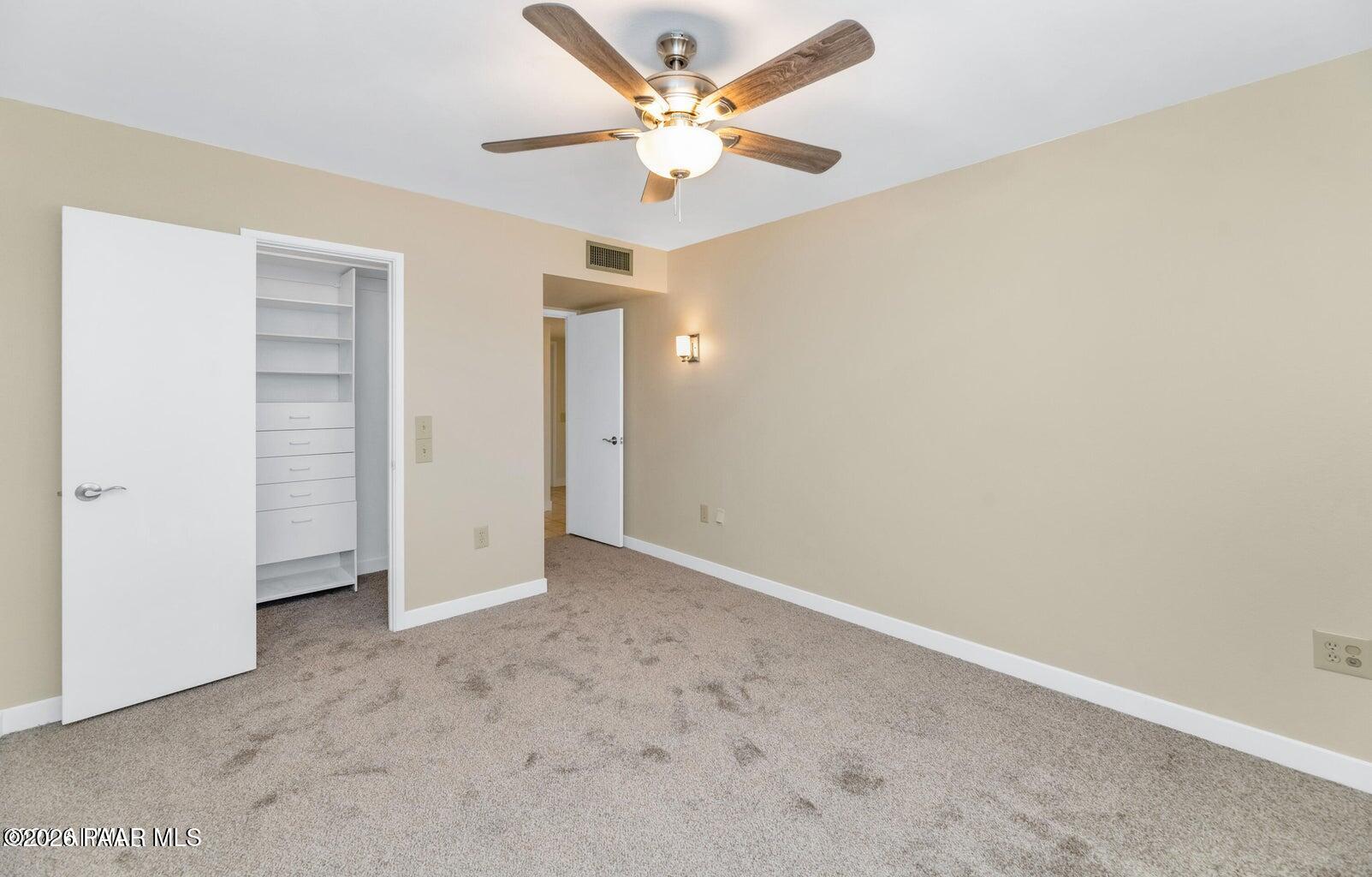 12602 West Rampart Drive Sun City, AZ 85375 - Photo 16 of 28 an empty room with closet and a ceiling fan