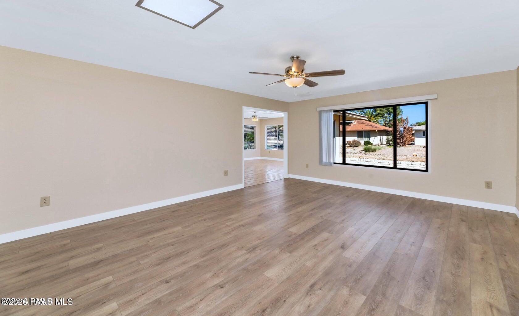 12602 West Rampart Drive Sun City, AZ 85375 - Photo 5 of 28 a view of empty room with wooden floor and fan