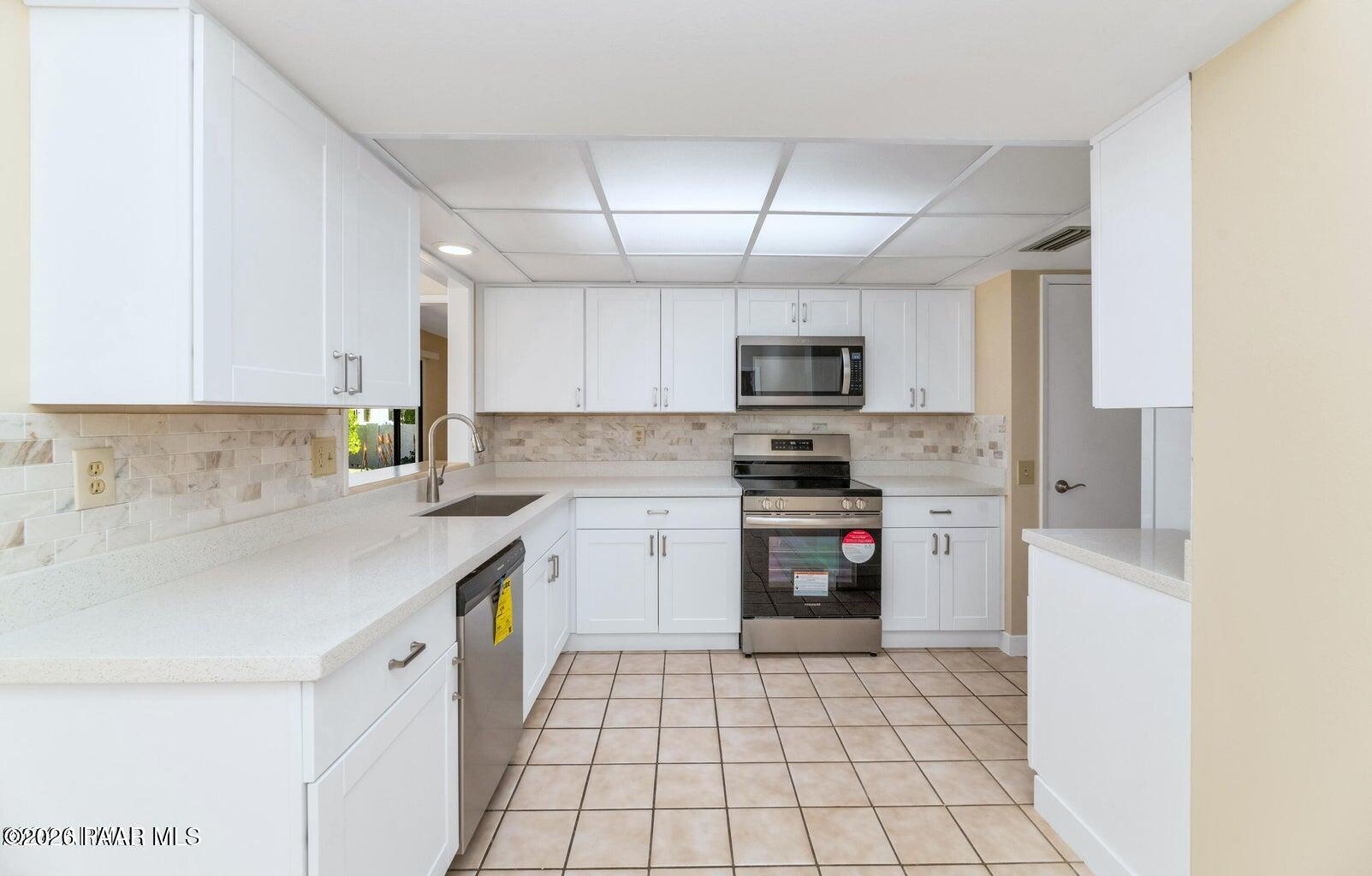 12602 West Rampart Drive Sun City, AZ 85375 - Photo 10 of 28 a kitchen with a sink a stove top oven and cabinets
