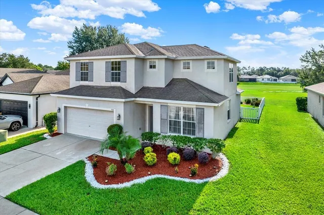 a front view of a house with a yard and potted plants