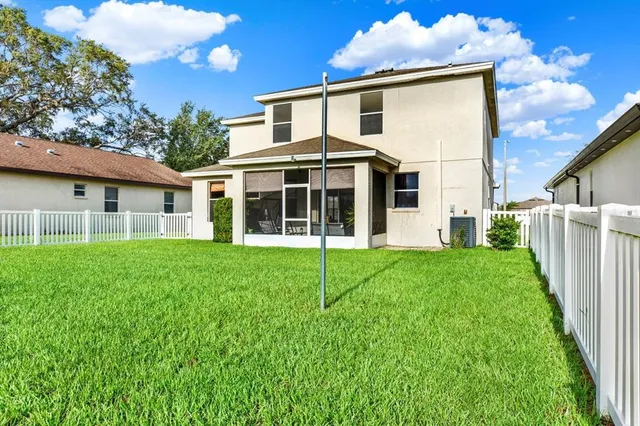 a front view of a house with a yard and potted plants