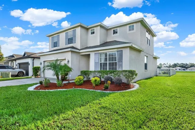 a front view of a house with a garden and plants