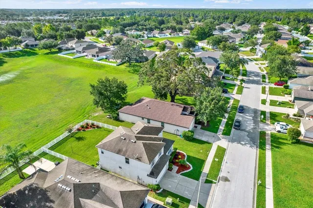 an aerial view of a residential houses with outdoor space and street view