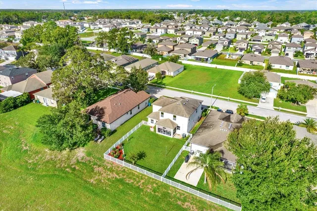 an aerial view of a house with a garden and lake view
