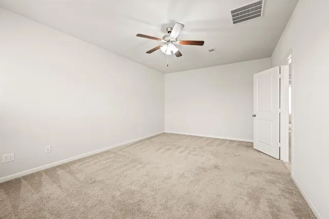 an empty room with a ceiling fan and a window