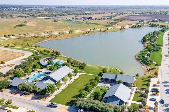 an aerial view of ocean and residential houses with outdoor space
