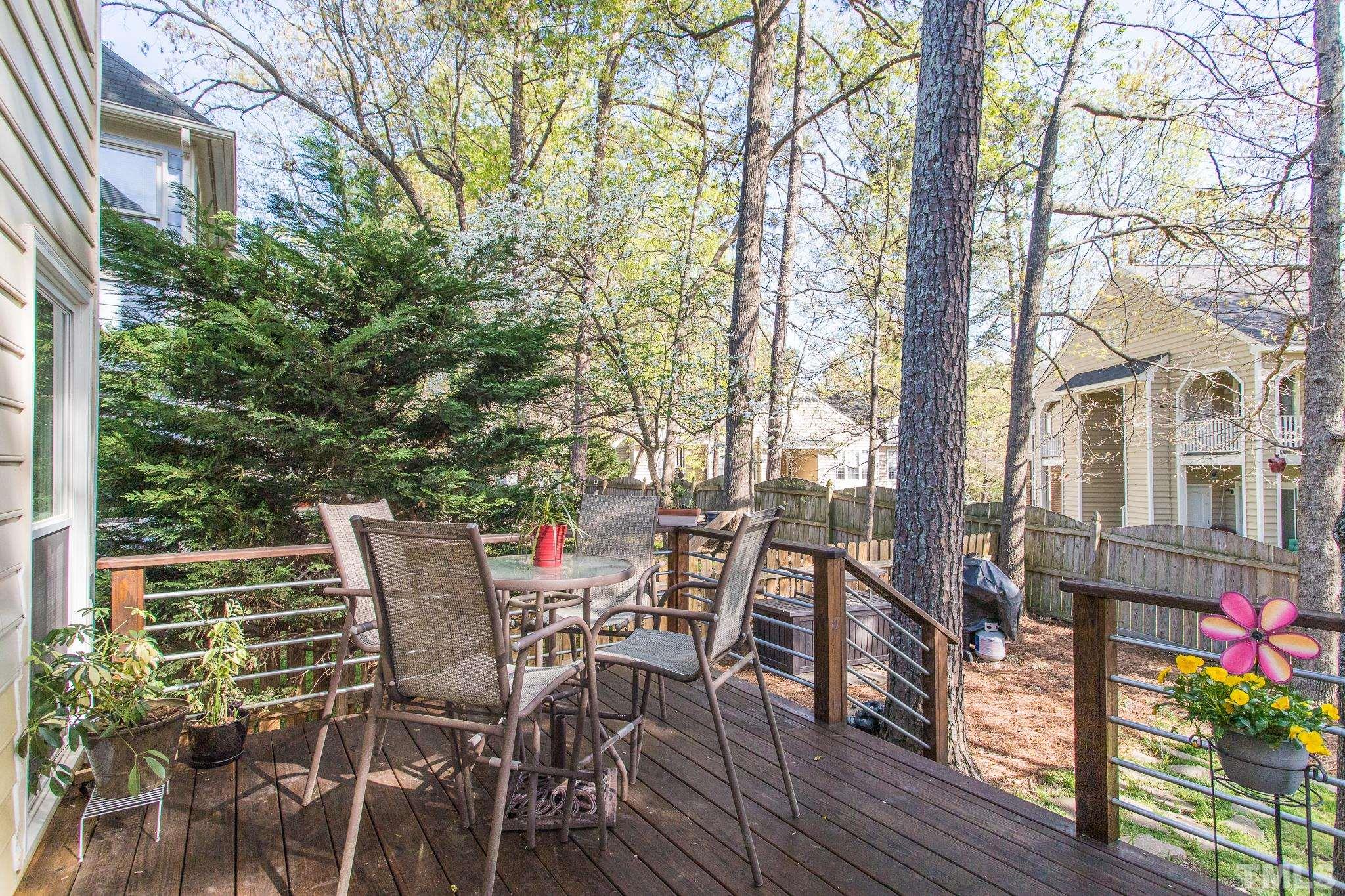 2352 Declaration Drive Raleigh, NC 27615 - Photo 26 of 28 a view of a patio with table and chairs and potted plants with wooden floor and fence