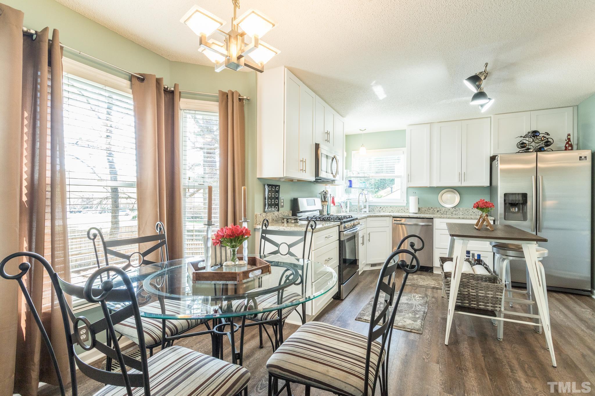 2352 Declaration Drive Raleigh, NC 27615 - Photo 8 of 28 a kitchen with stainless steel appliances a table and chairs in it