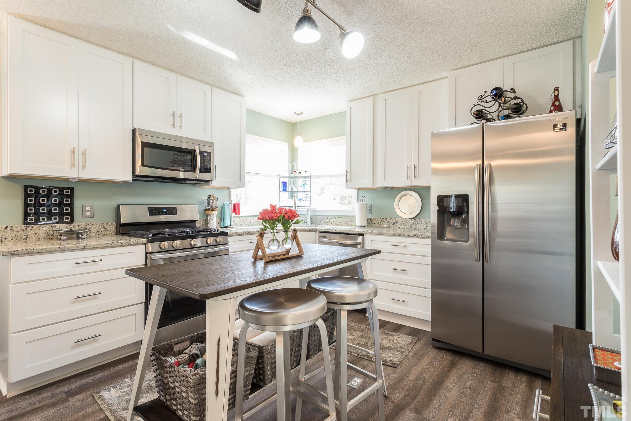 2352 Declaration Drive Raleigh, NC 27615 - Photo 9 of 28 a kitchen with refrigerator cabinets dining table and chairs