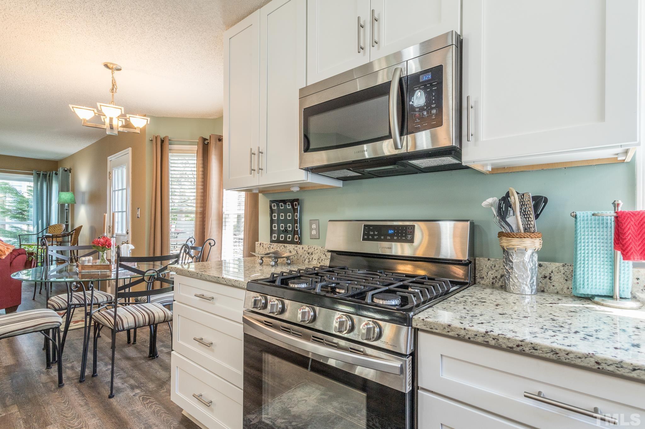 2352 Declaration Drive Raleigh, NC 27615 - Photo 10 of 28 a kitchen with stainless steel appliances granite countertop a stove a sink and a microwave