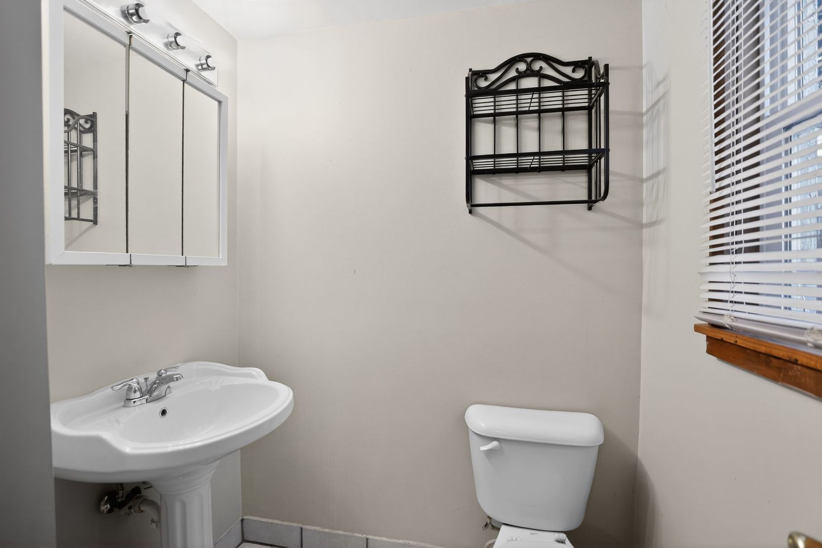 1250 West American Street Freeport, IL 61032 - Photo 10 of 23 a bathroom with a sink a mirror and a toilet