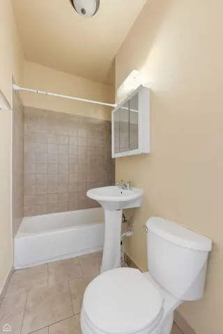 a white toilet sitting next to a bath tub