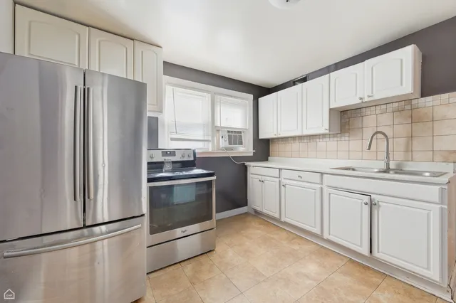 a kitchen with stainless steel appliances granite countertop a refrigerator sink and stove