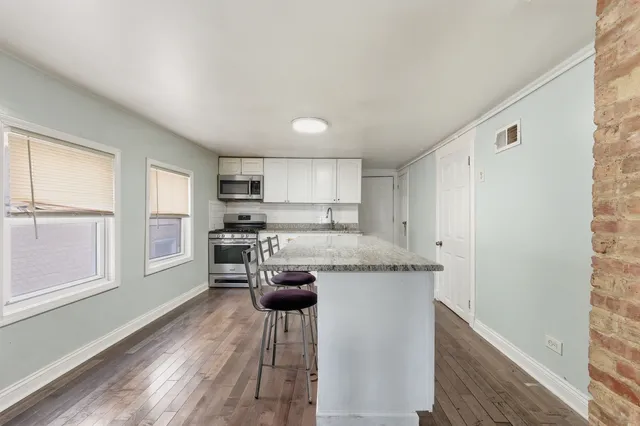 a kitchen with stainless steel appliances granite countertop a stove a sink refrigerator and a microwave