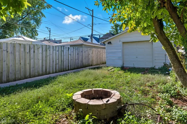 a view of a backyard with table and chairs and a fire pit