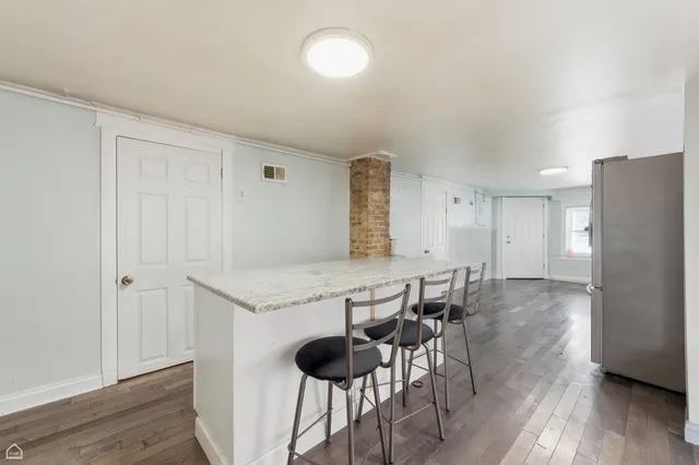 a dining hall with stainless steel appliances granite countertop a refrigerator and a stove top oven