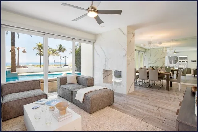 a kitchen with stainless steel appliances kitchen island granite countertop a refrigerator a sink a dining table and chairs