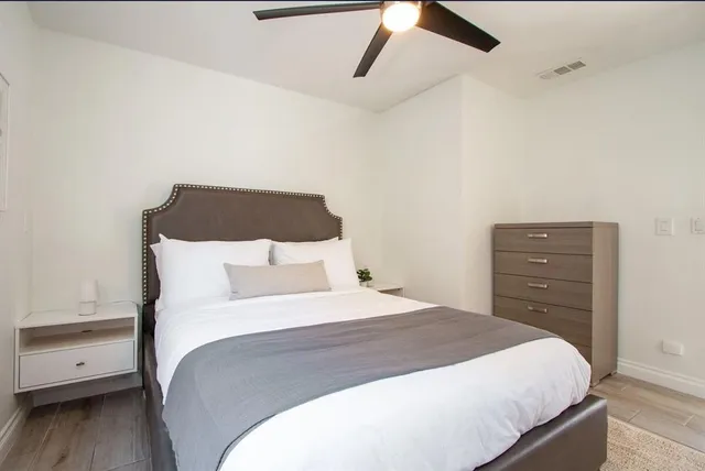 a bedroom with a bed a window and a flat screen tv