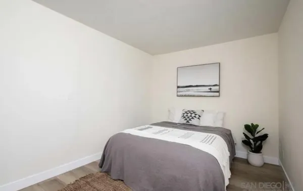 a bedroom with a bed and painting on the wall