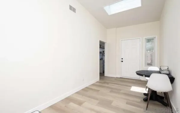 a view of a room with chairs and wooden floor