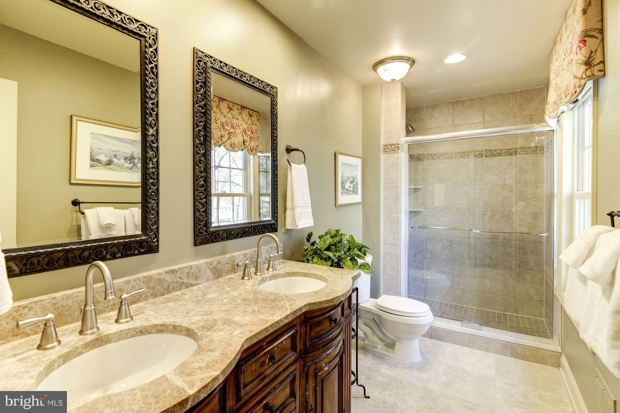 11630 Quail Ridge Court Reston, VA 20194 - Photo 16 of 29 a bathroom with a granite countertop sink toilet a mirror and shower