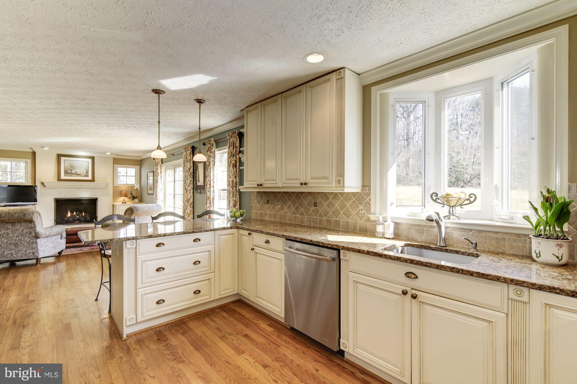 11630 Quail Ridge Court Reston, VA 20194 - Photo 8 of 29 a kitchen with granite countertop a sink cabinets stainless steel appliances and a large window