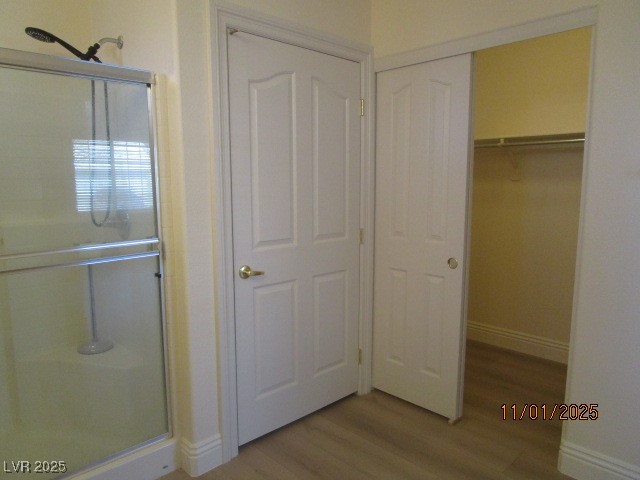 8661 Little Fox Street Las Vegas, NV 89123 - Photo 11 of 18 Full bathroom with light wood-type flooring, a stall shower, and a walk in closet