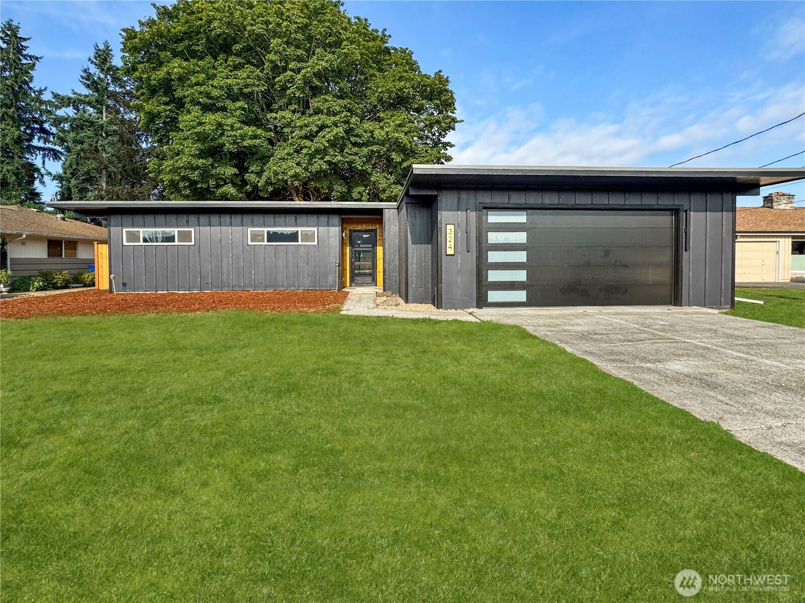a front view of a house with yard and trees