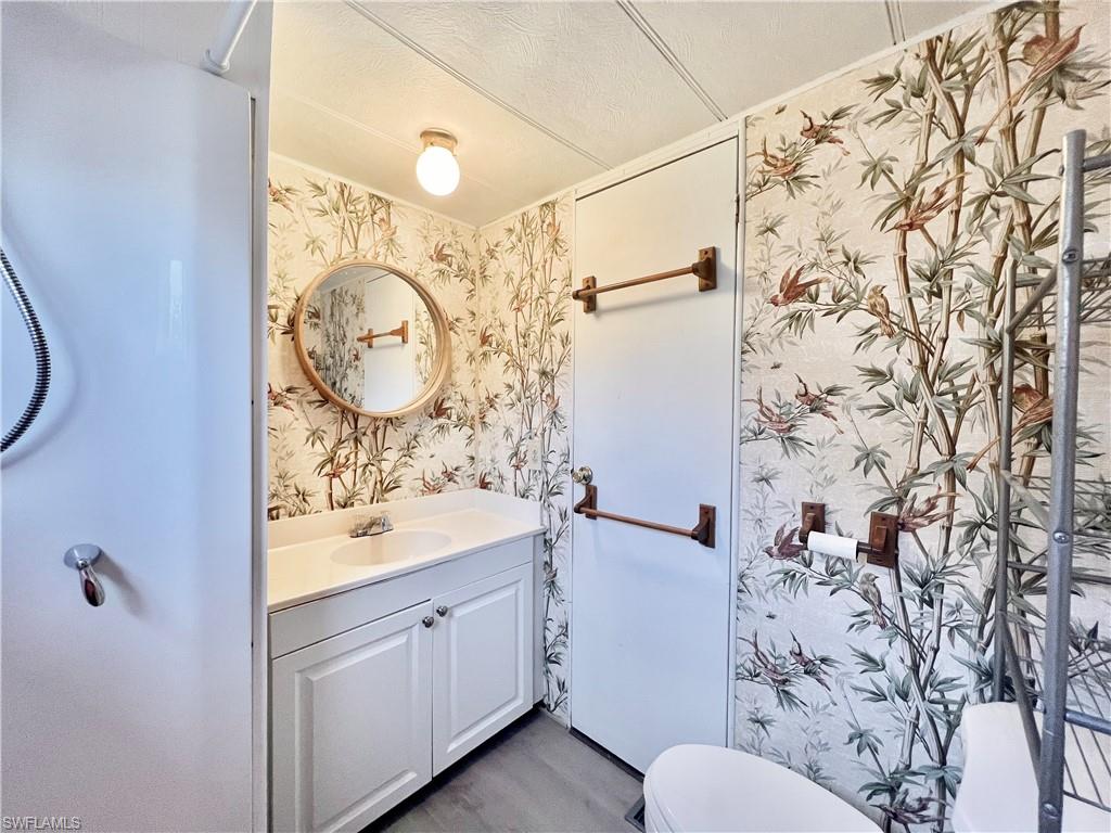 112 Cape Sable Drive Naples, FL 34104 - Photo 11 of 35 a bathroom with a sink and a mirror