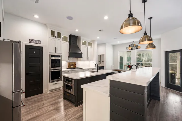 a kitchen with stainless steel appliances kitchen island a sink cabinets and wooden floor