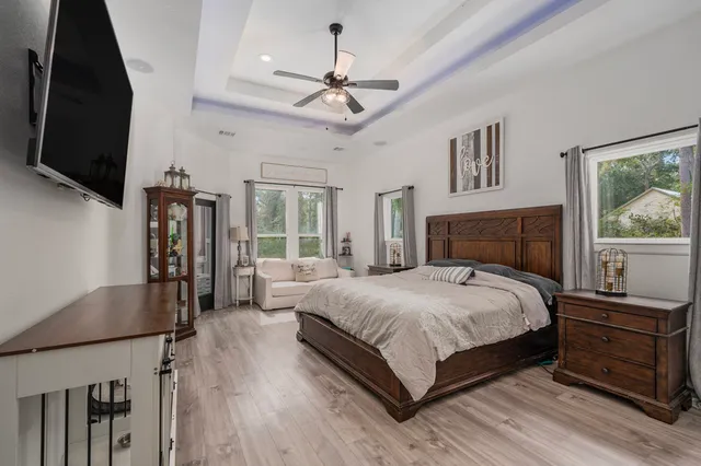 a bedroom with a large bed a flat tv screen and a dresser