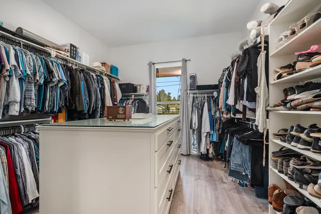 a view of walk in closet with clothes and shoes