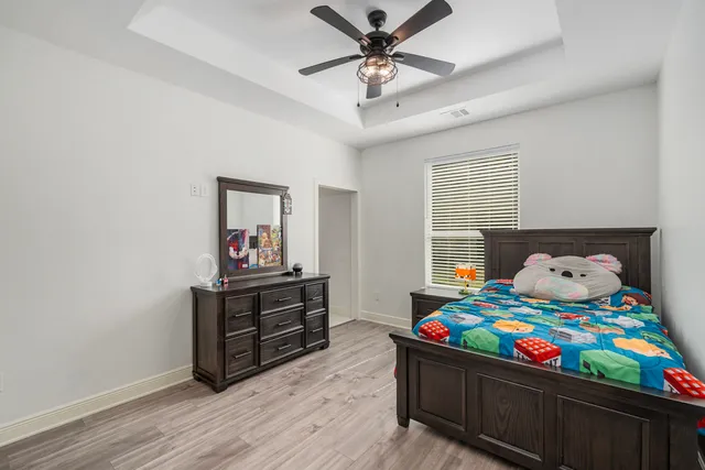a bedroom with a bed and wooden floor