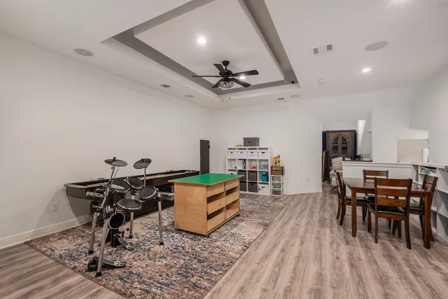 a living room with furniture a piano and a bookshelf
