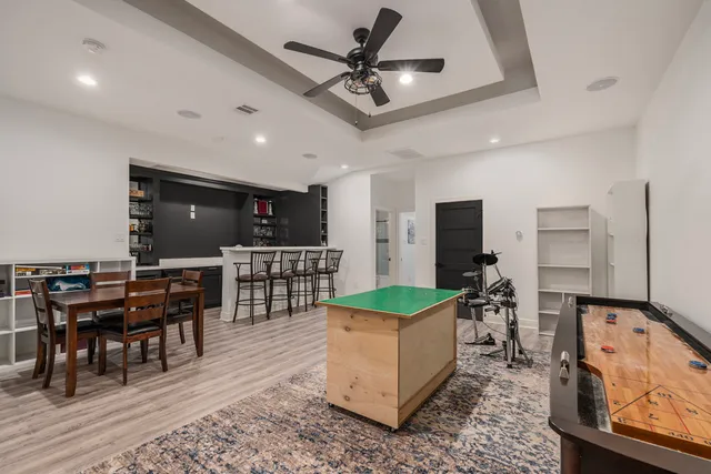 a kitchen with stainless steel appliances kitchen island granite countertop a table chairs and a refrigerator