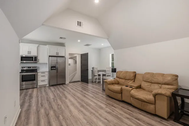 a living room with furniture and kitchen view