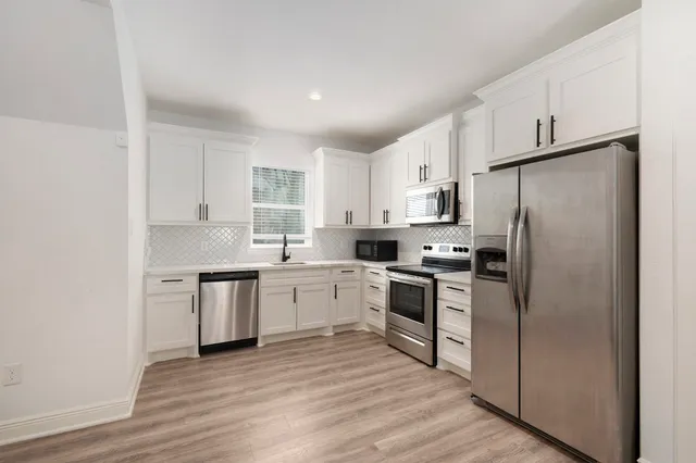 a kitchen with a refrigerator stove top oven and sink