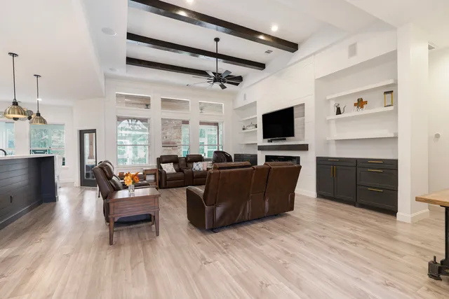 a living room with furniture a ceiling fan and a flat screen tv