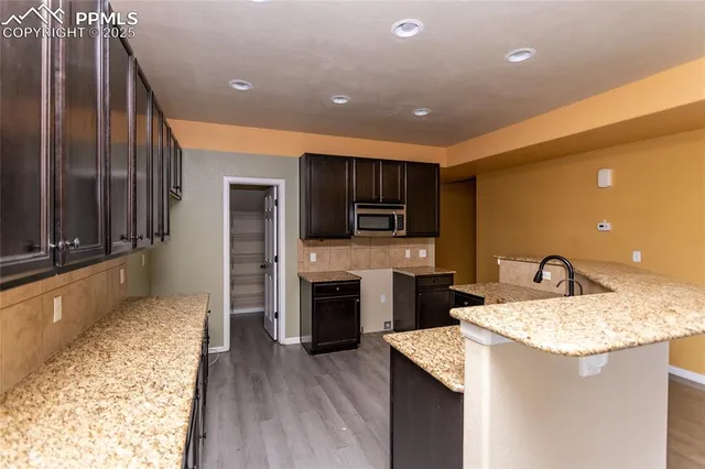 a kitchen with kitchen island granite countertop stainless steel appliances and sink