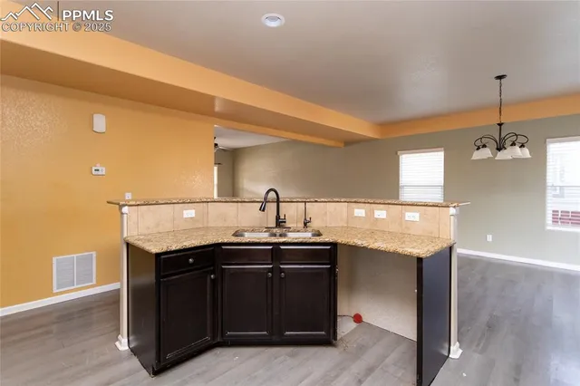 a kitchen with granite countertop a sink and cabinets