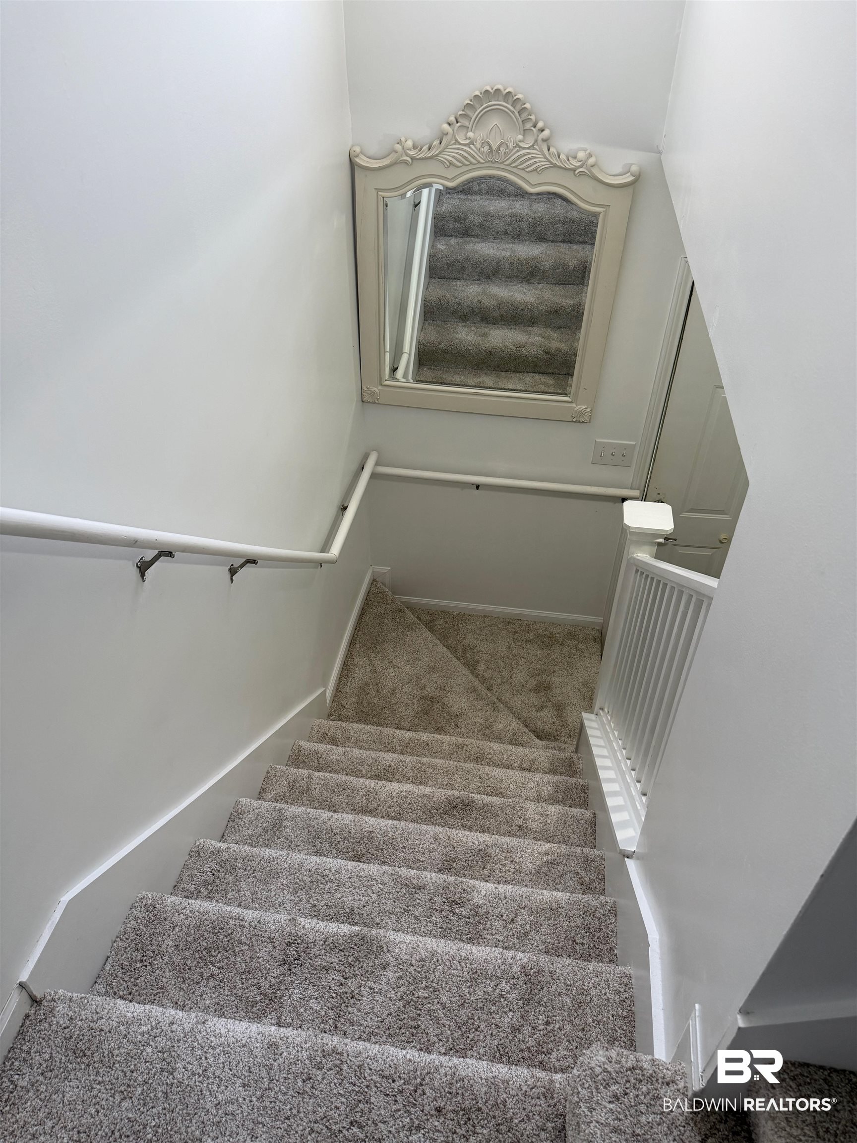 1517 Regency Road, Unit 71 Gulf Shores, AL 36542 - Photo 8 of 26 Stairway with carpet and baseboards