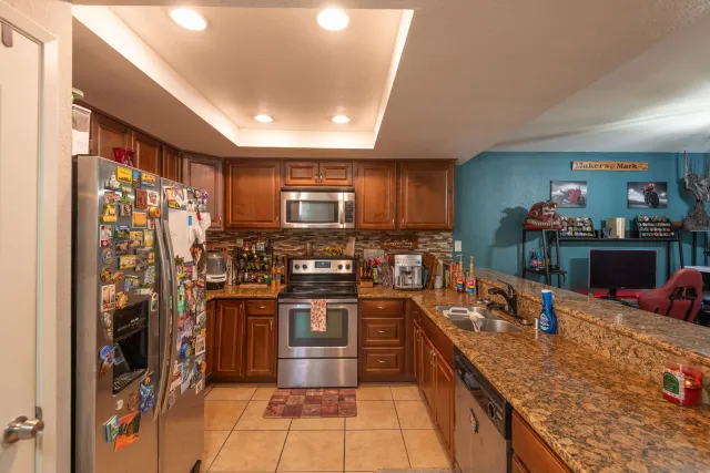 a kitchen with stainless steel appliances granite countertop a refrigerator and a stove top oven