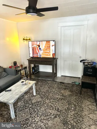 a living room with furniture a rug and a wall painting