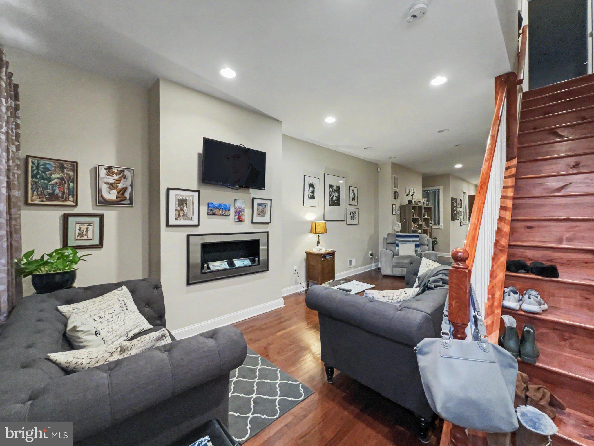 1610 North Broadway Baltimore, MD 21213 - Photo 2 of 18 a living room with furniture a flat screen tv and a fireplace