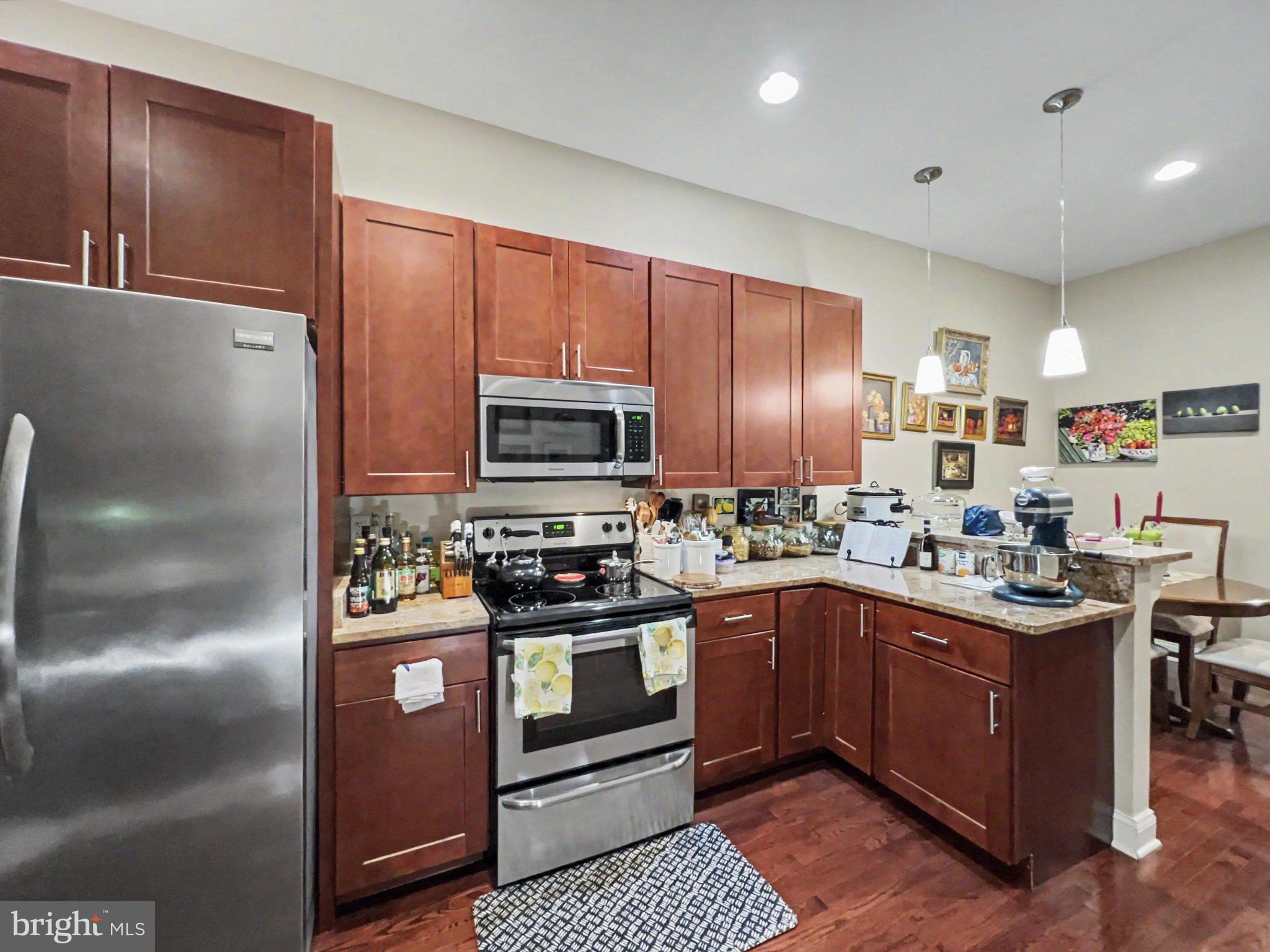 1610 North Broadway Baltimore, MD 21213 - Photo 4 of 18 a kitchen with kitchen island granite countertop stainless steel appliances and wooden cabinets