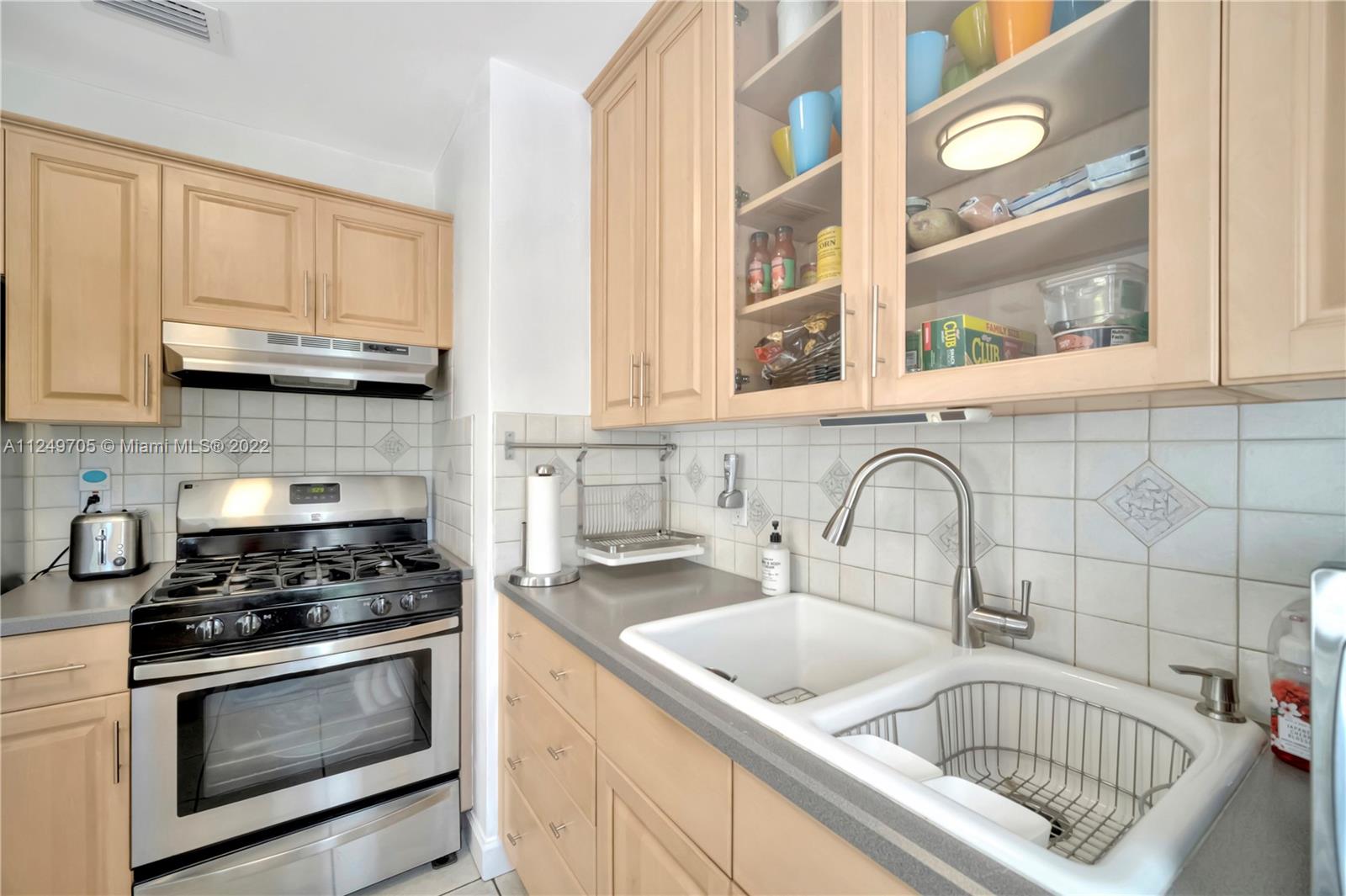 4290 Southwest 11th Street Miami, FL 33134 - Photo 11 of 20 a kitchen with granite countertop a stove a sink and a microwave