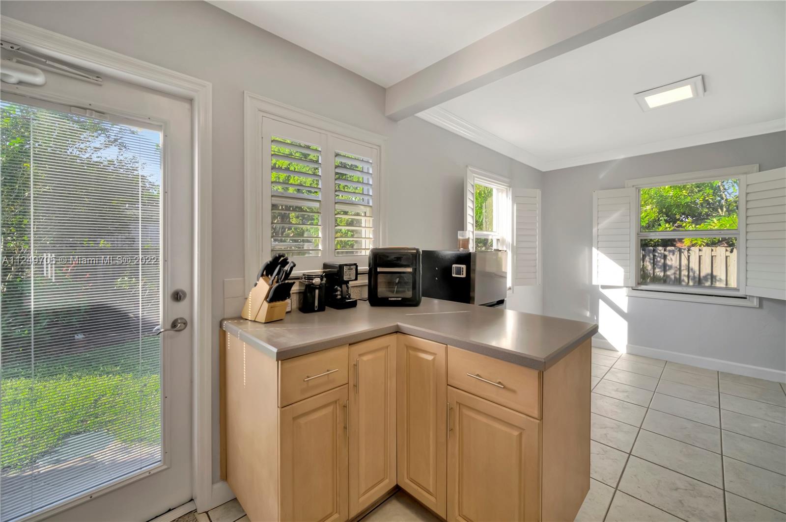 4290 Southwest 11th Street Miami, FL 33134 - Photo 12 of 20 a kitchen with kitchen island granite countertop a sink cabinets and wooden floor