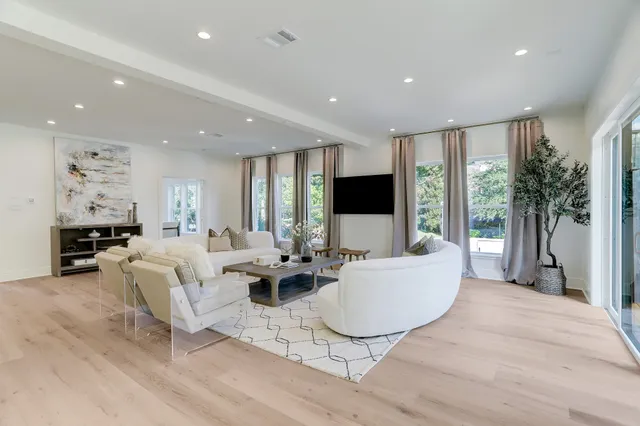 a living room with furniture a flat screen tv and a large window