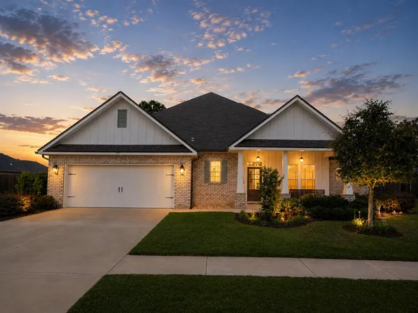 a front view of a house with a yard and outdoor seating